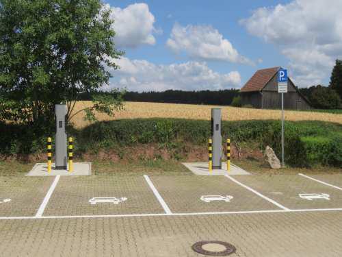 Vier Parkplätze zum Laden von Elektroautos mit zwei Ladesäulen Parkhinweis
